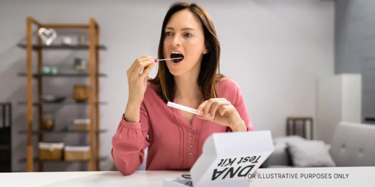 A woman swabbing her inner mouth for a DNA test | Source: Shutterstock